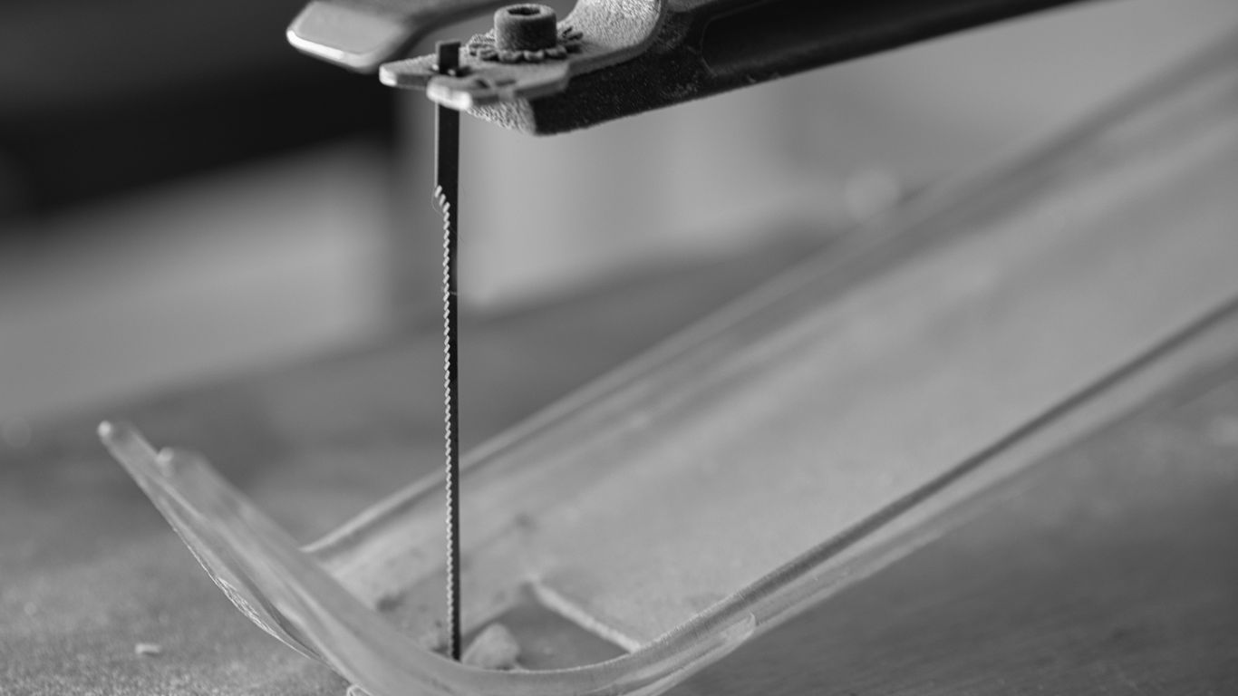 a pair of pliers cutting a piece of glass