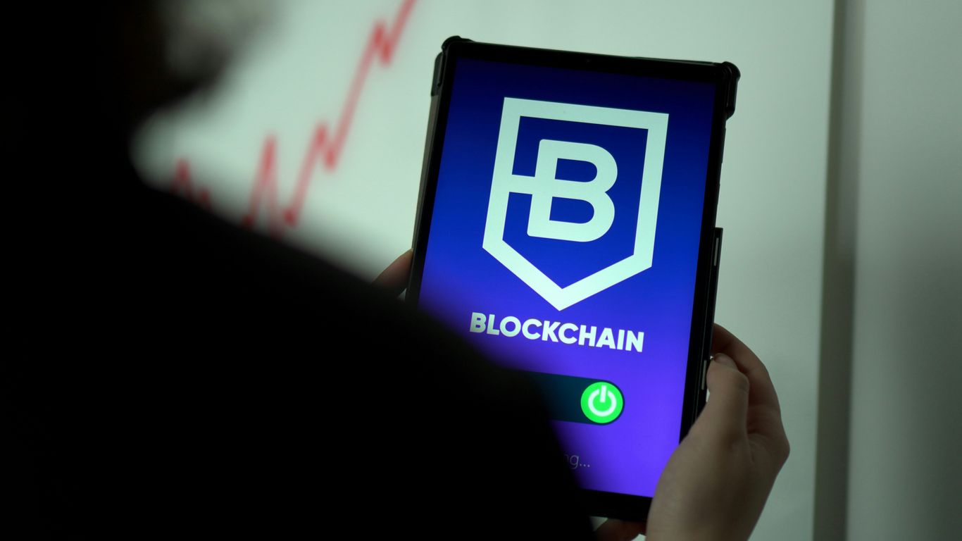 Person holding a tablet displaying a blockchain logo and graph.