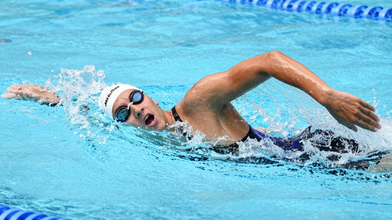 Swimmer executing advanced freestyle stroke in Australian pool.