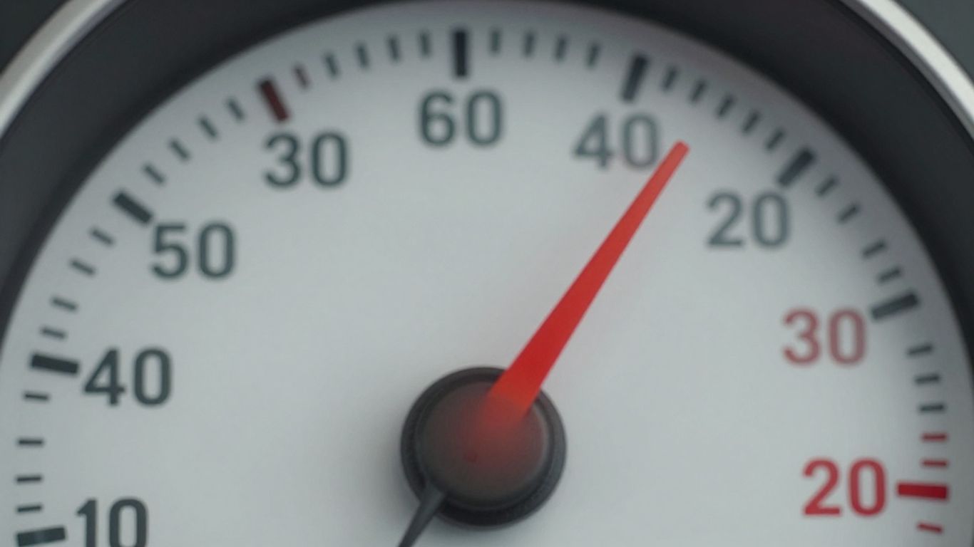Digital speedometer nearing its limit with a glowing data pipe.