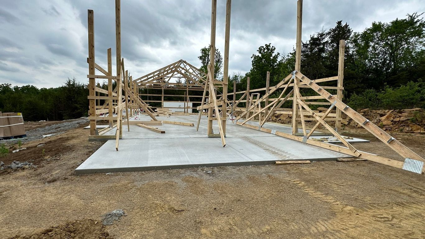 Wooden frame of a building under construction on a cloudy day.