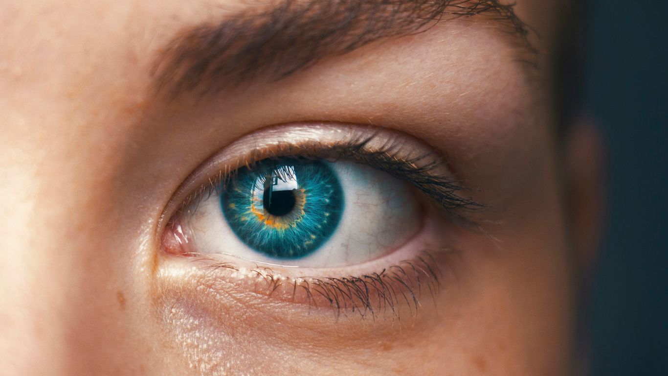 A glowing robotic eye on a black background