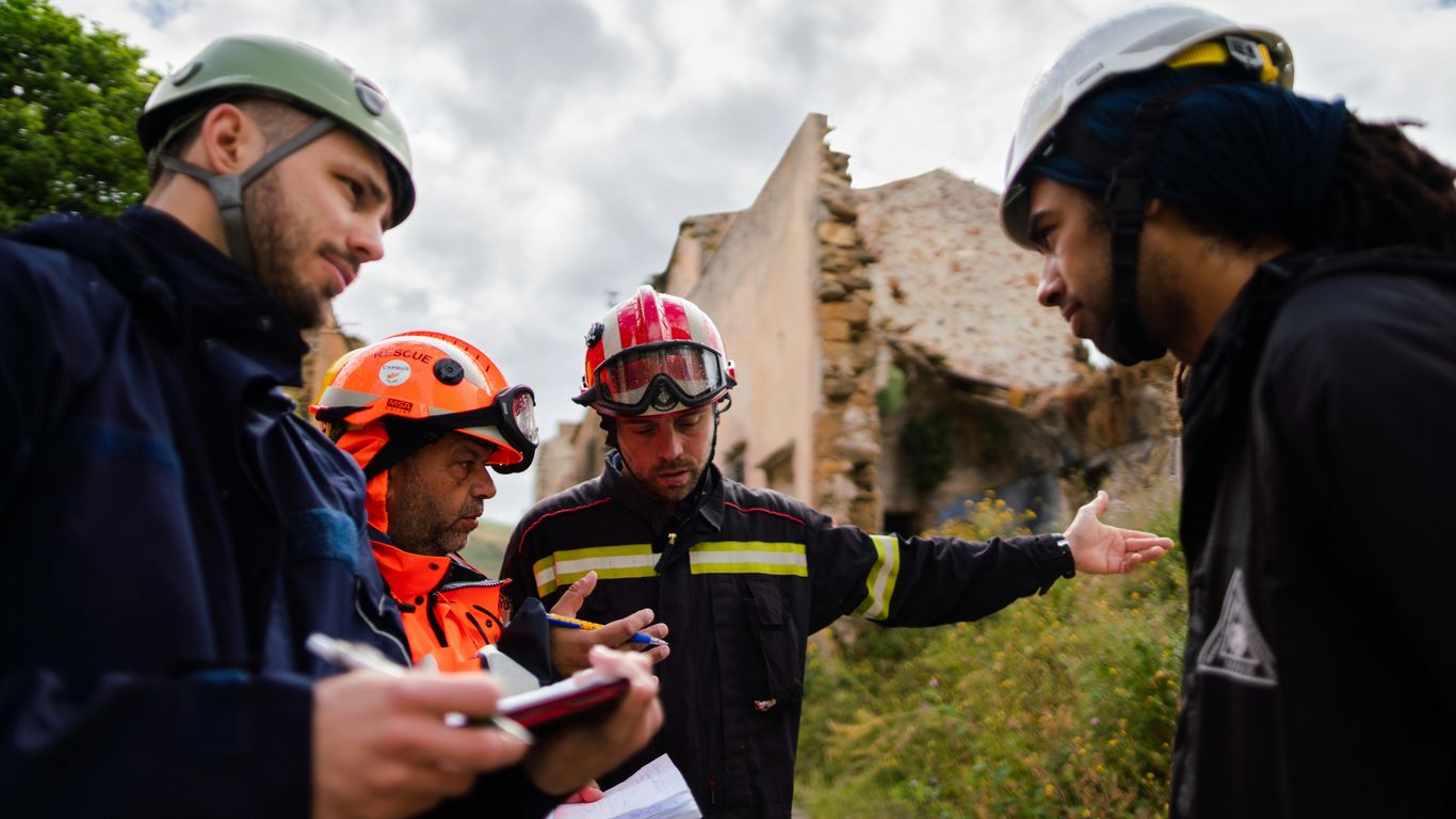 2 men in blue and orange jacket wearing helmet
