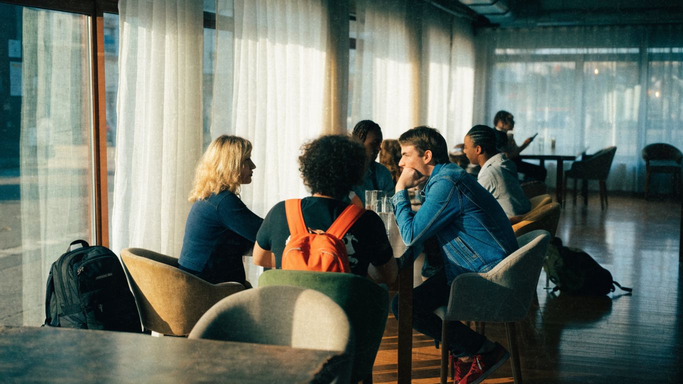 A bright hostel lounge with travellers relaxing together