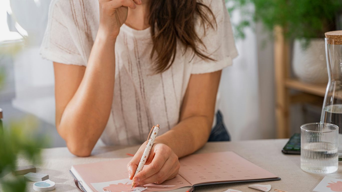 a woman writing on a piece of paper
