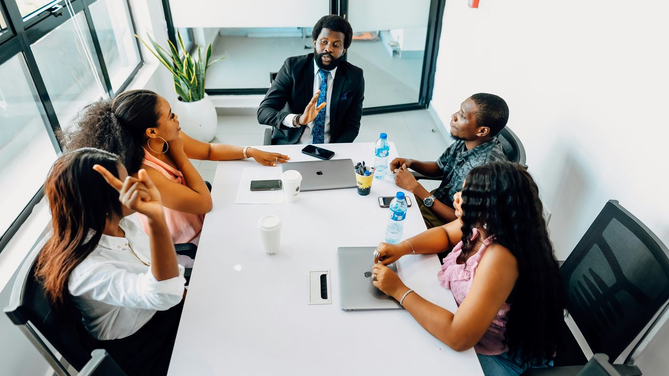 A group of people sitting around a white table