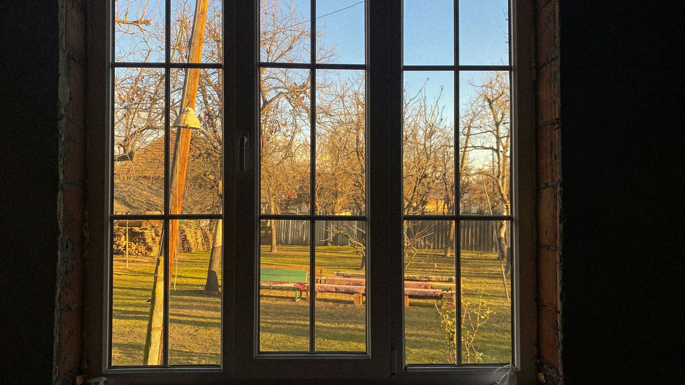 a window with a view of a field and a crane