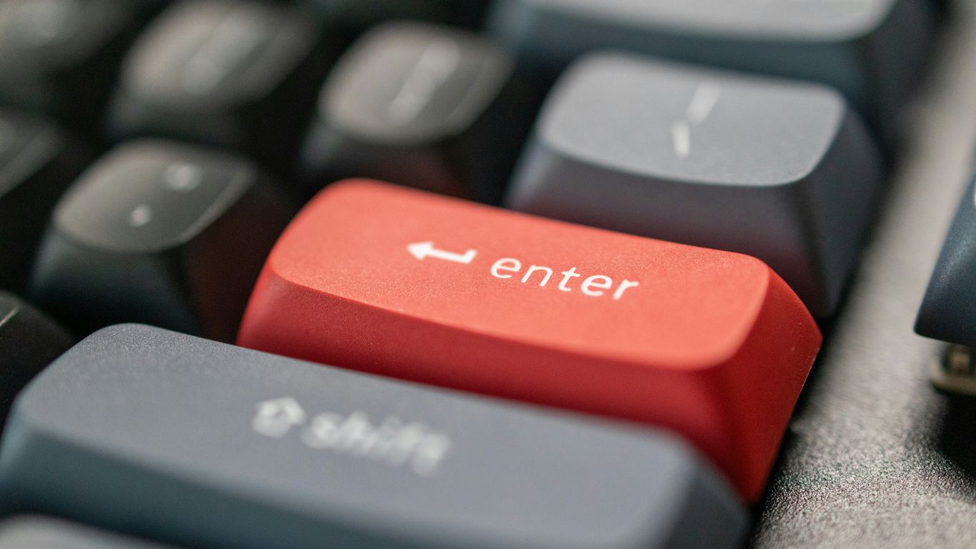 a computer keyboard with a red enter button