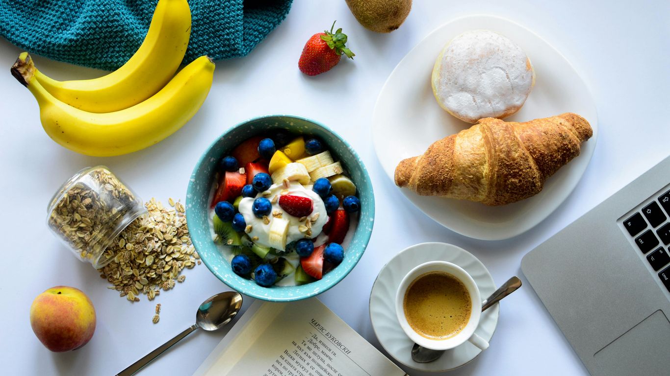 A wooden table filled with fresh breakfast ingredients