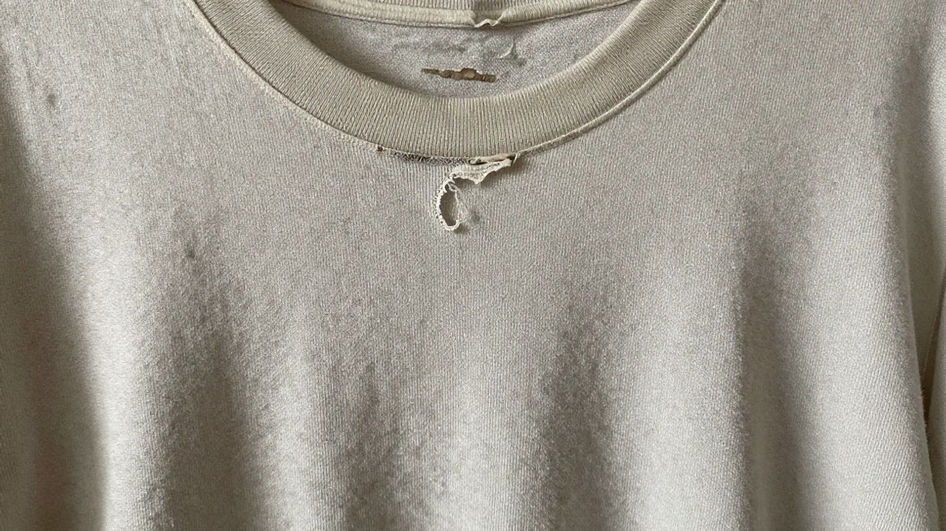 Damaged, faded t-shirt showing signs of wear and tear.