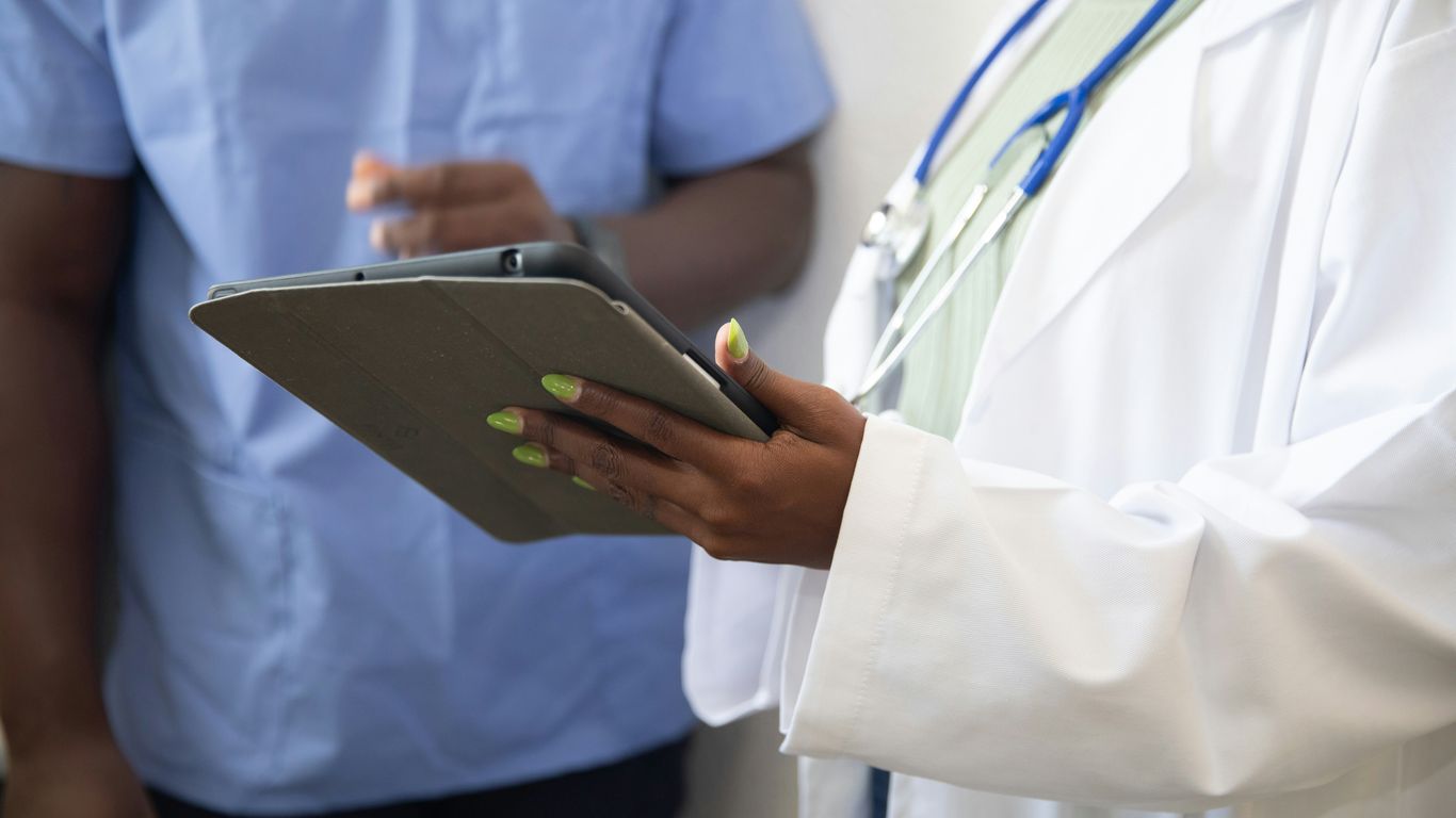 a doctor showing a patient something on the tablet