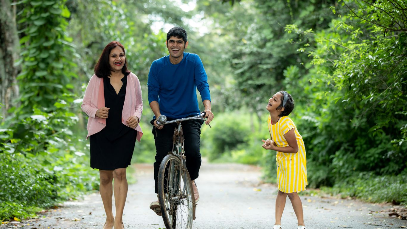 a man riding a bike with two women and a child