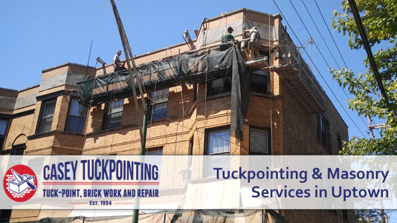 Building undergoing tuckpointing and masonry services with workers on scaffolding.