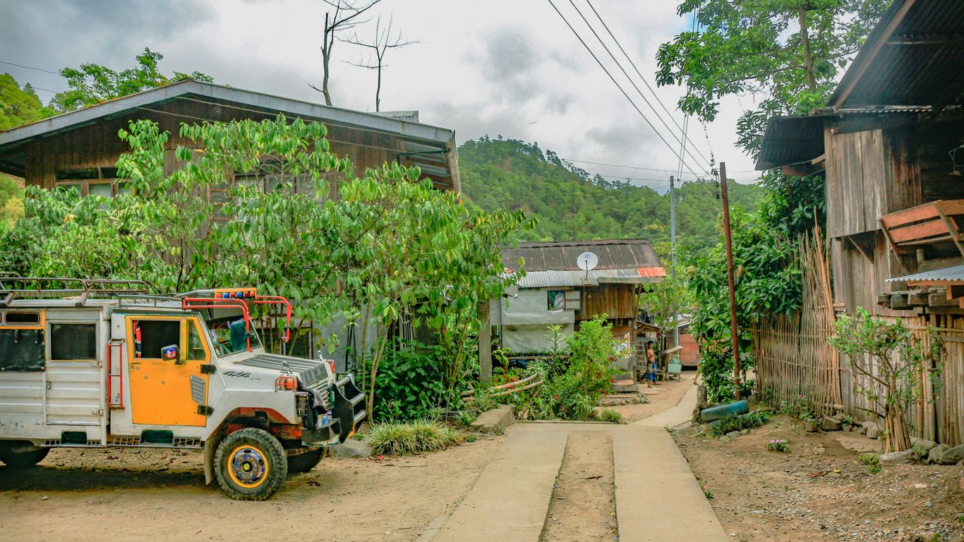 yellow and black truck near brown house during daytime