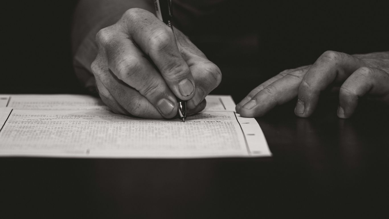 Hand writing with a fountain pen on paper.