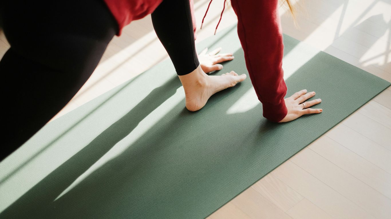 Hands gripping yoga mat during workout