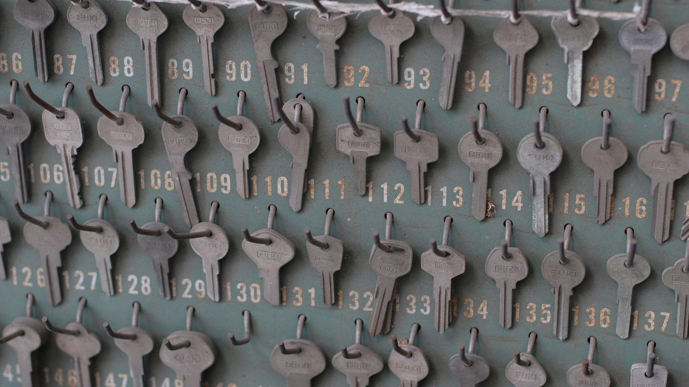 Many numbered keys hanging on a wall board.