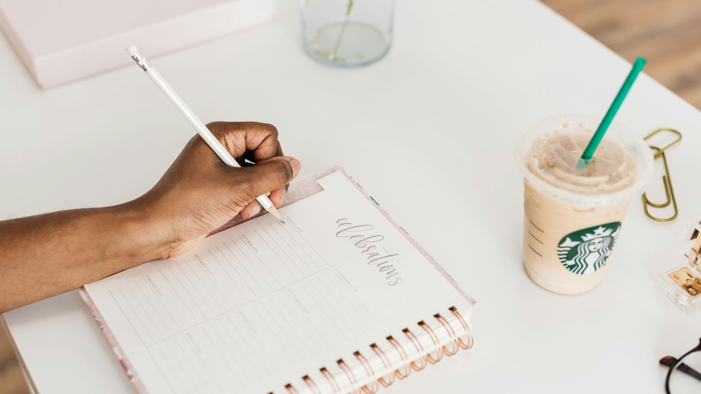 person writing on notebook