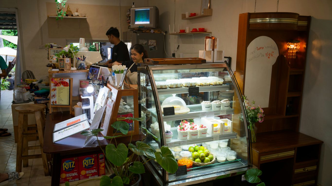 Dessert display case in a cozy cafe interior.