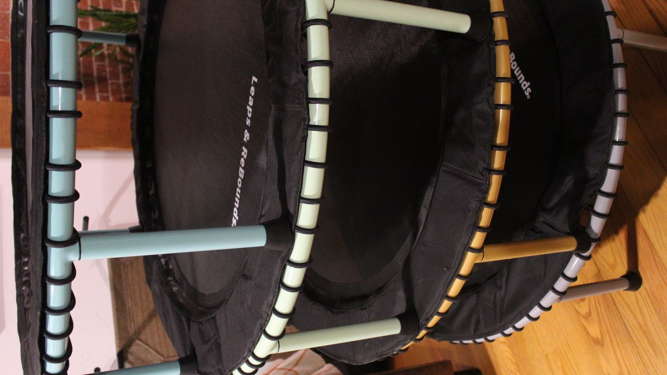 Four mini trampolines stacked together on a wooden floor.