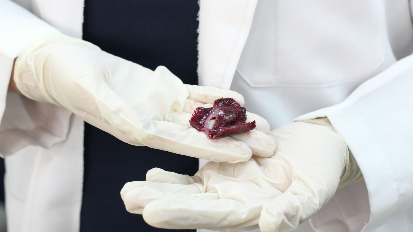 a person wearing white gloves holding a piece of fruit