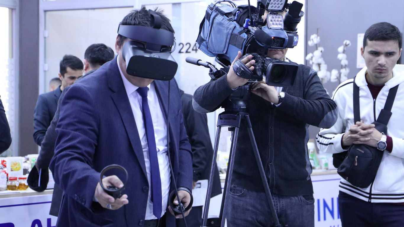 a group of people standing around a table with a camera