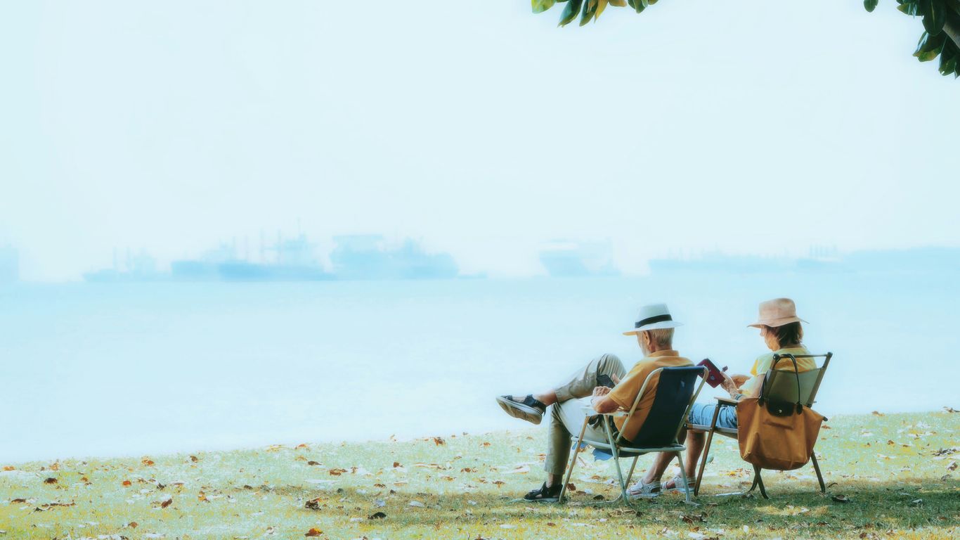 Elderly couple relaxing by the ocean.