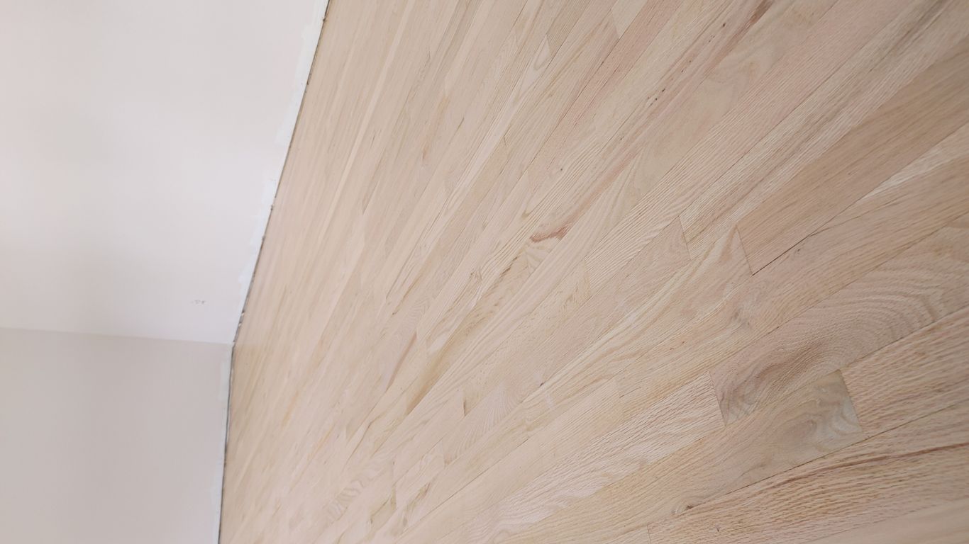 Light-colored hardwood flooring in an empty room.