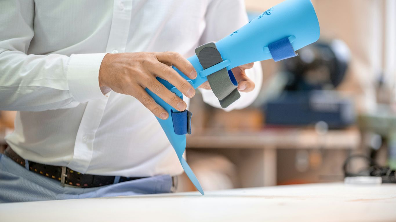 a man holding a blue hair dryer on top of a table