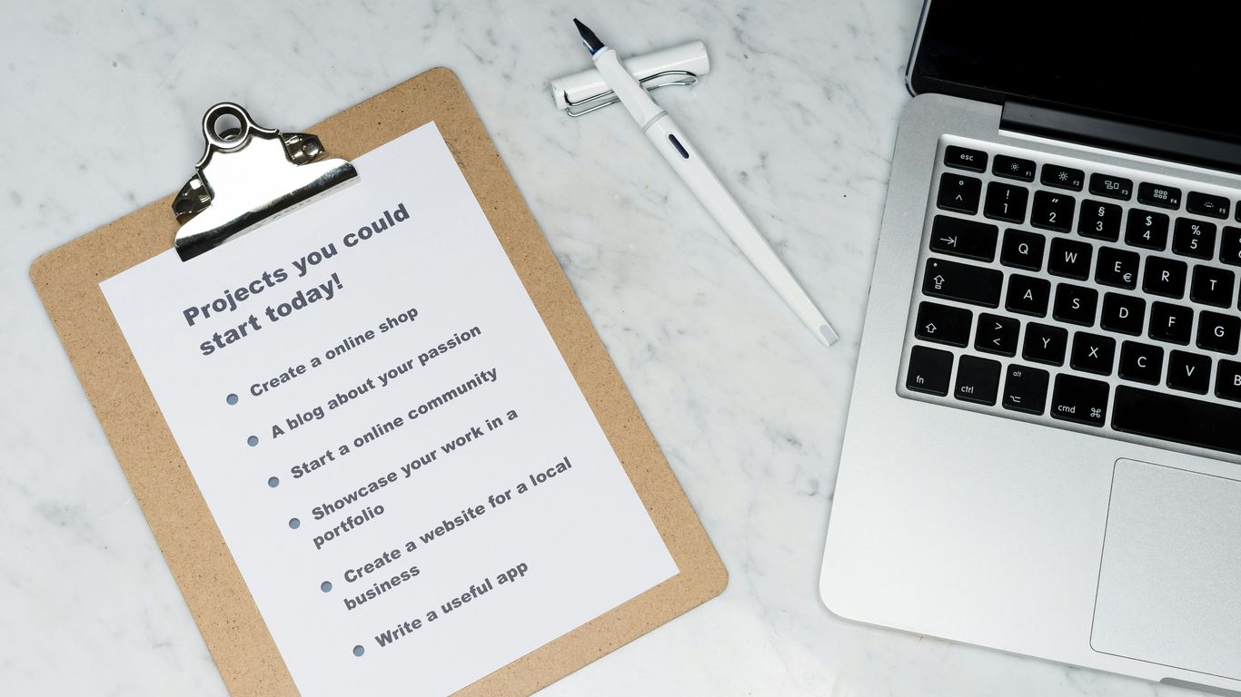 white printer paper beside silver laptop computer