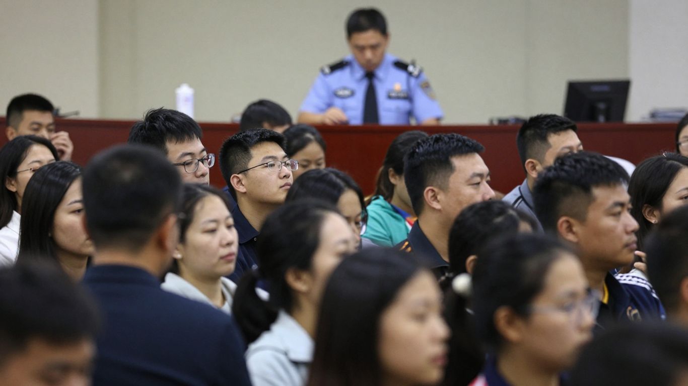 Immigration waiting room with many people and long delays.