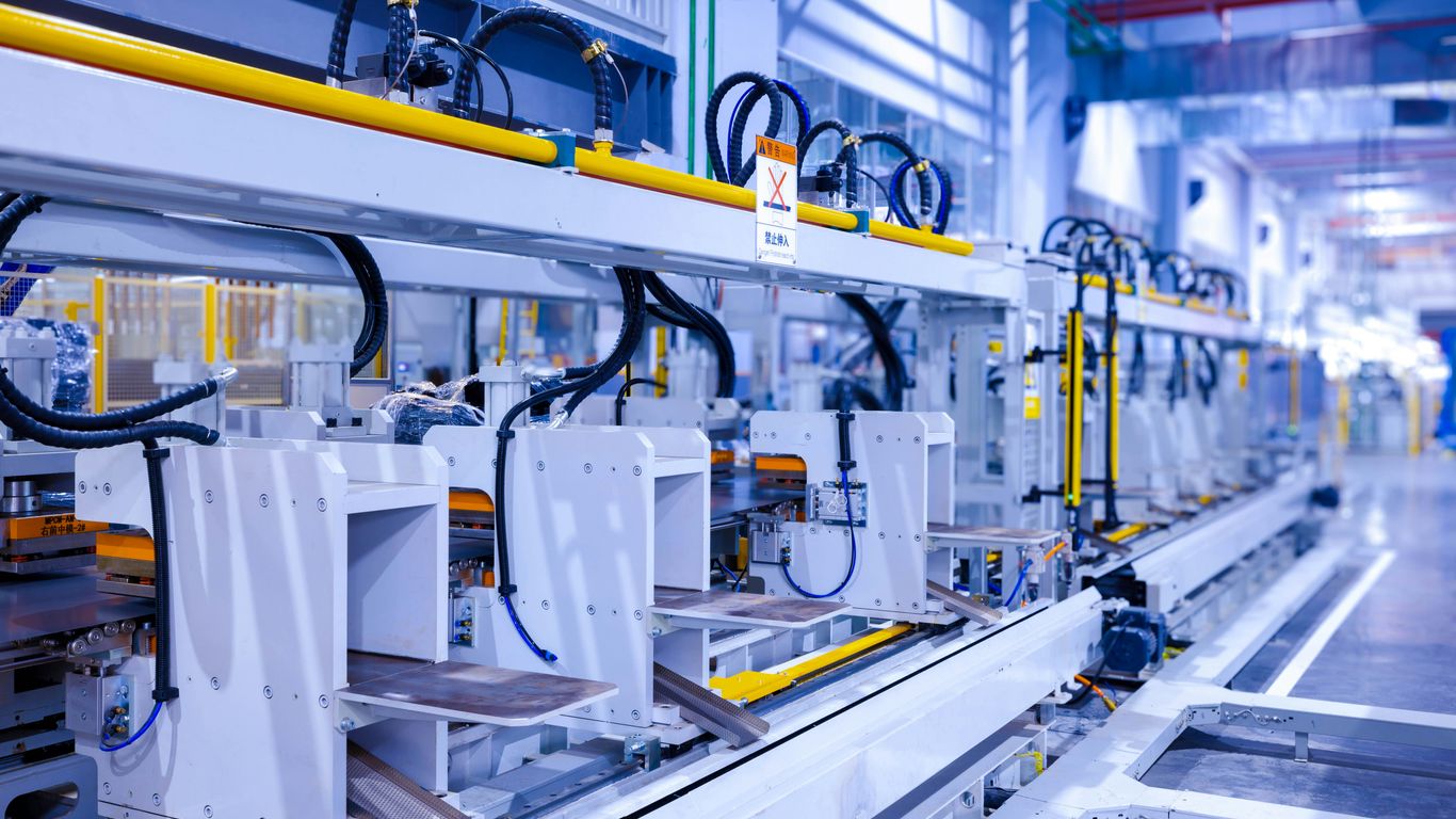 Factory operator inspecting circuit board assembly