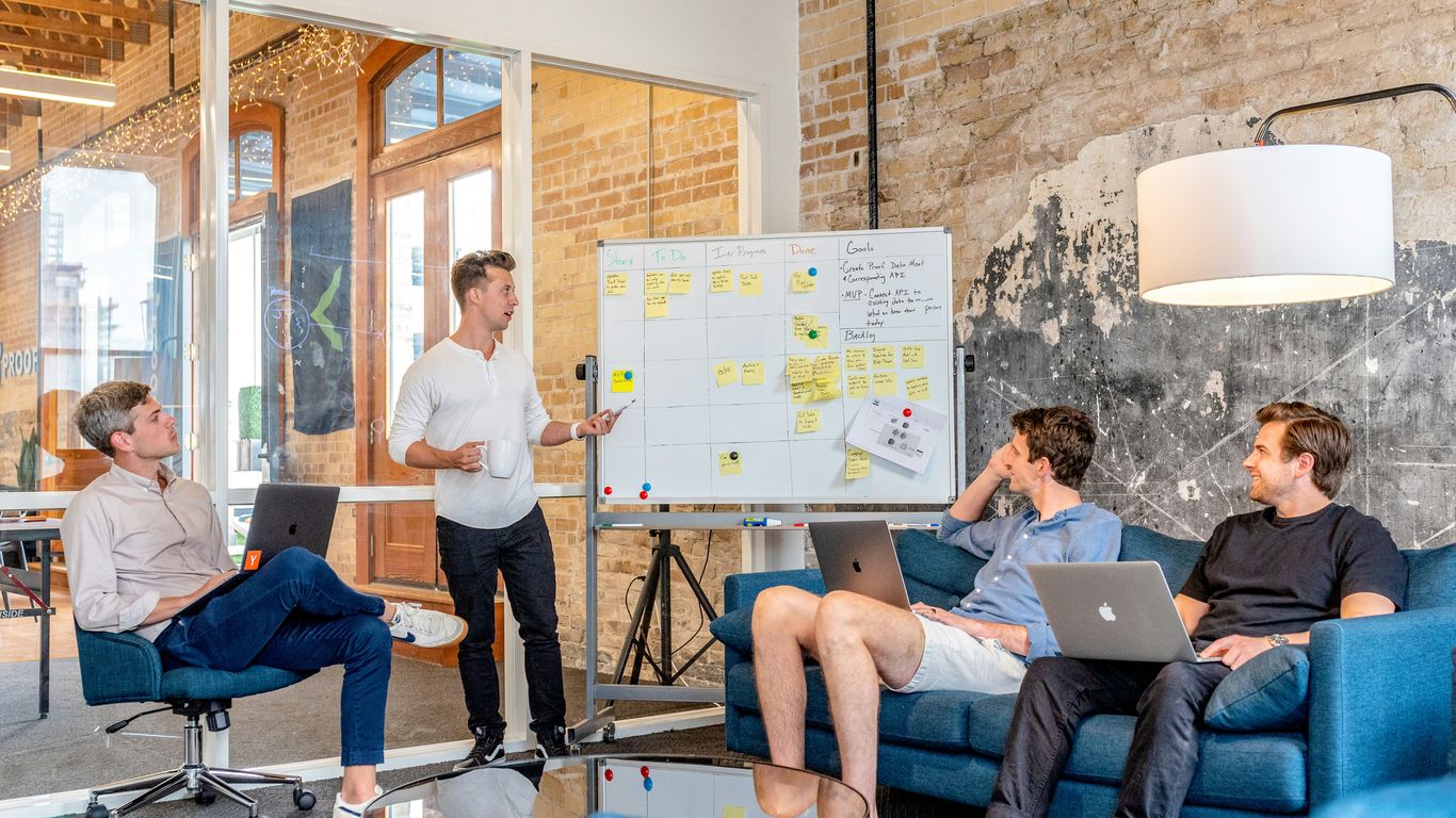 A creative marketing team reviewing visual content ideas on a wall board
