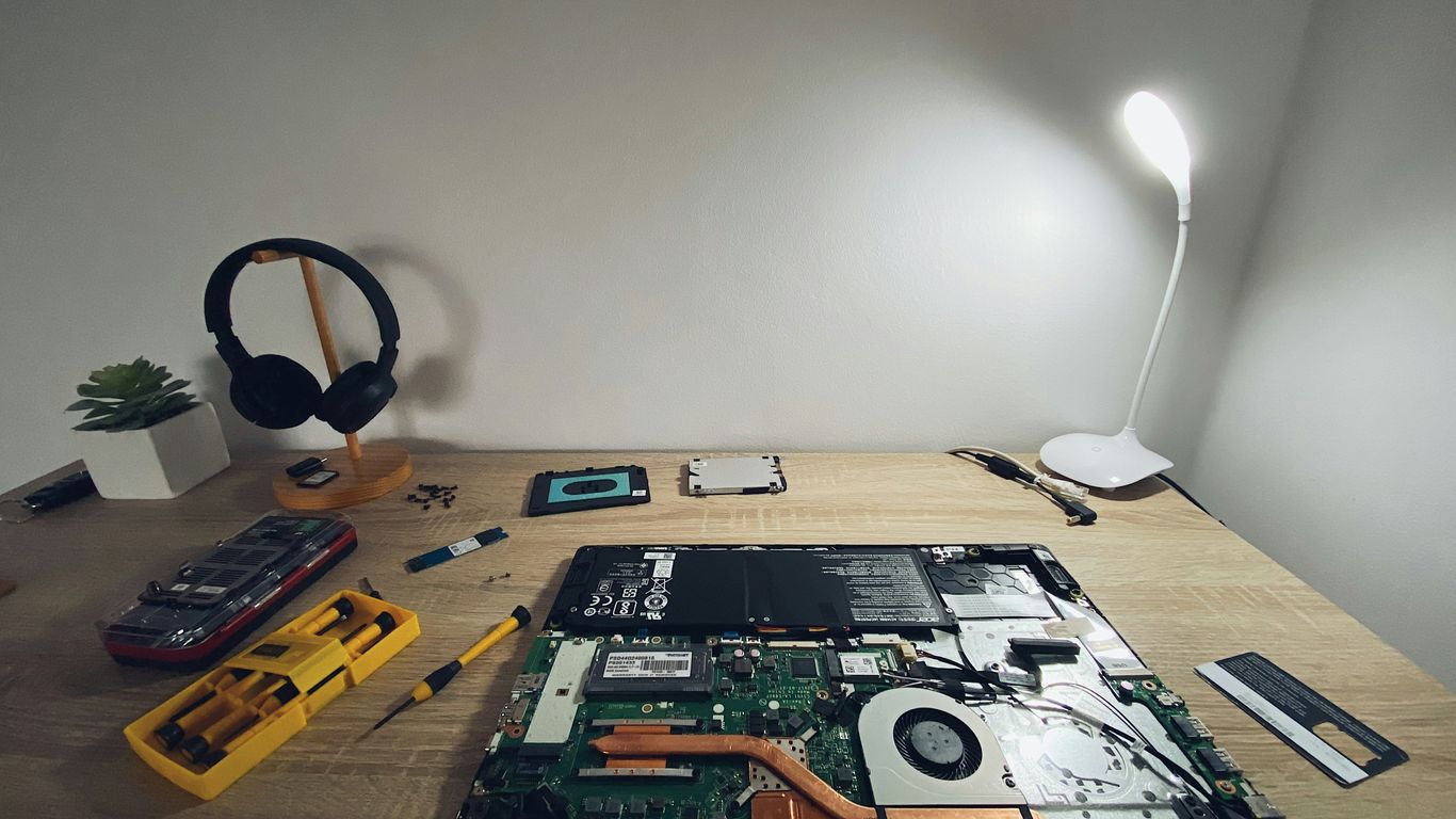 a table with a laptop and headphones on it