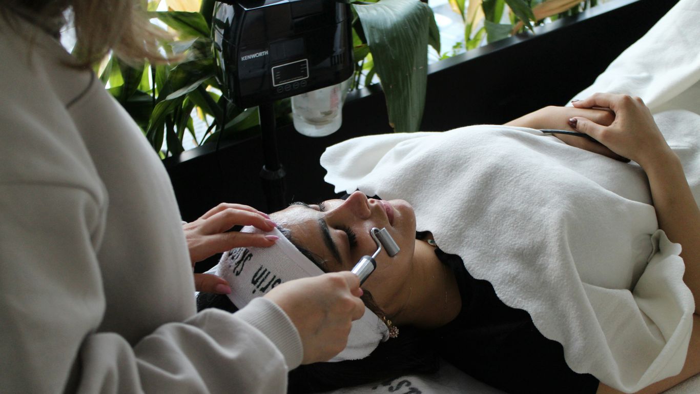 A woman laying on a bed while using a cell phone