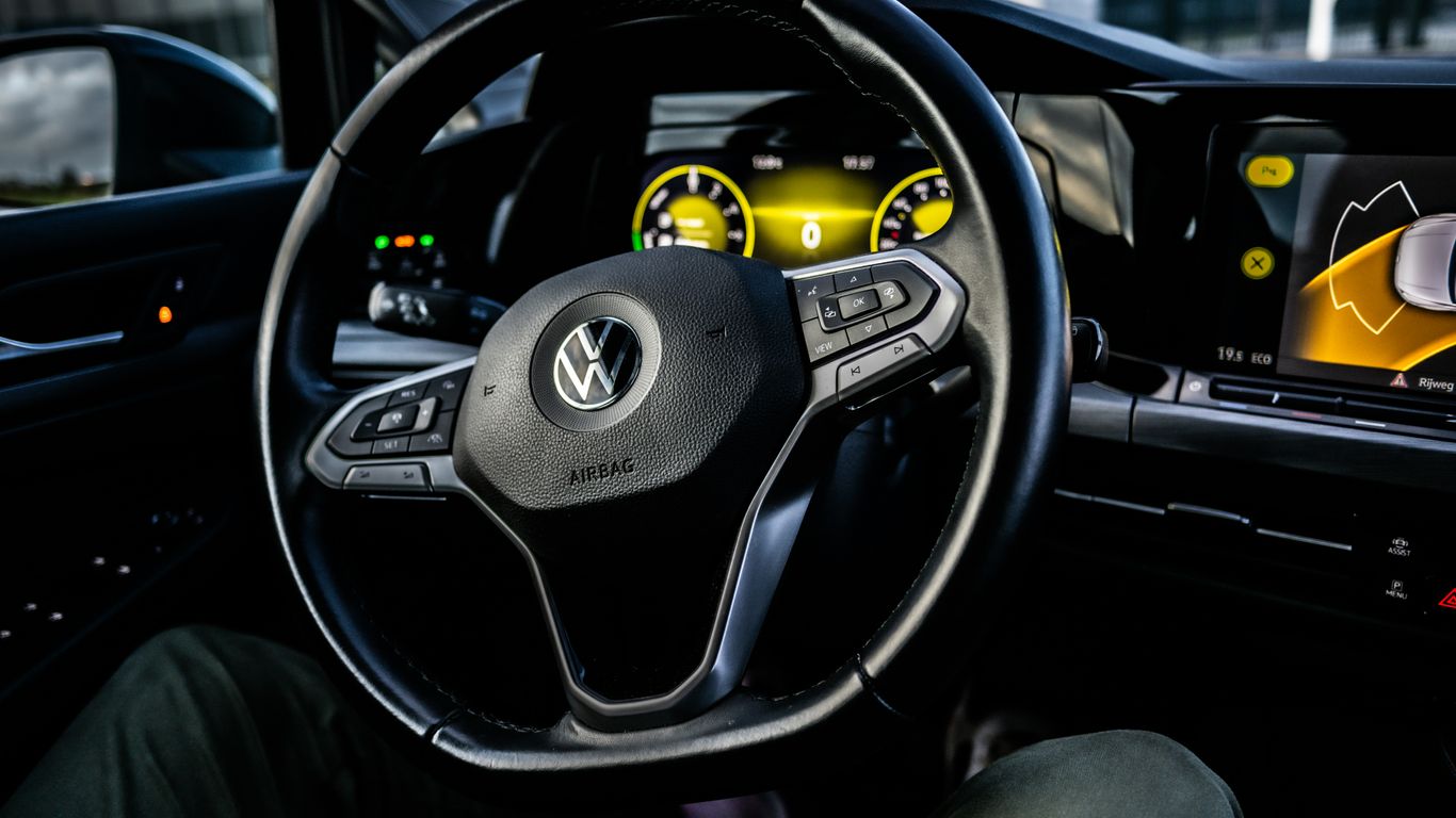 a car dashboard with a steering wheel and dashboard lights