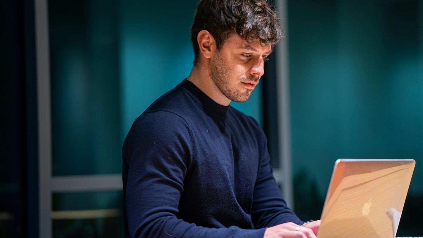 man in black long sleeve shirt using macbook