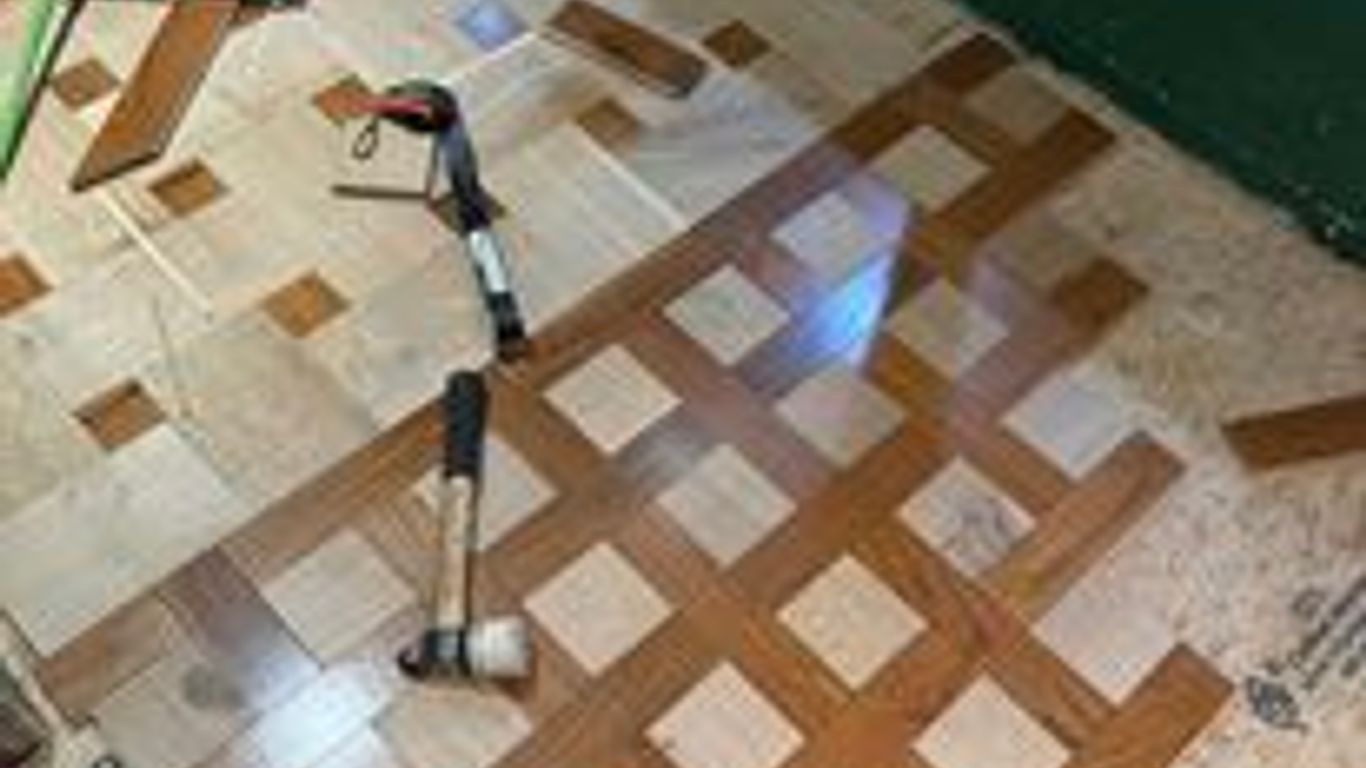 Wood floor installation with patterned tiles and tools visible.