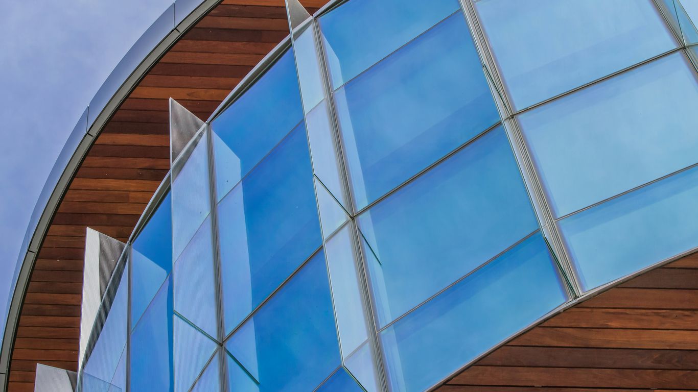 a close up of a curved building with a sky background