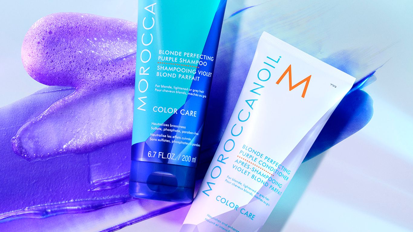 Two Moroccanoil shampoo bottles against an artistic, blue-toned background.