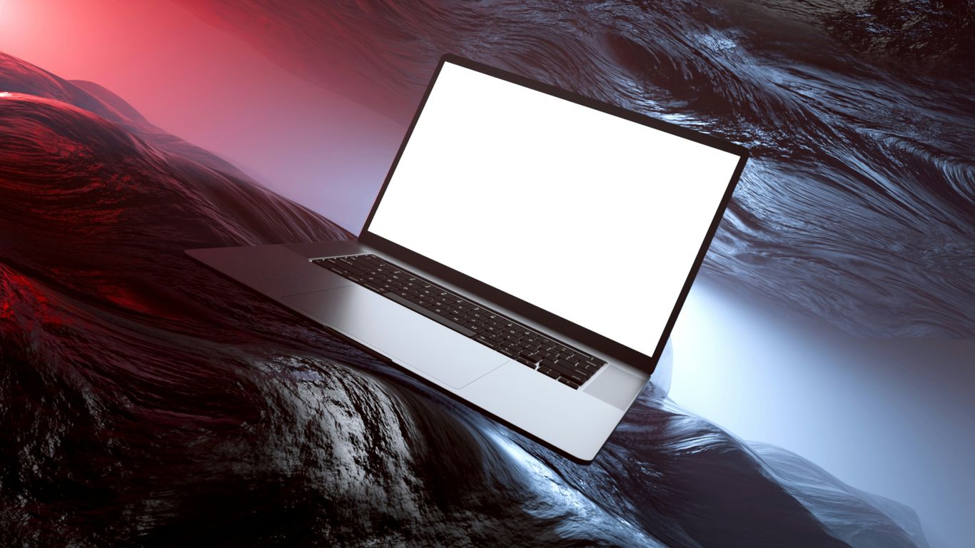 A modern laptop on a textured, abstract surface.