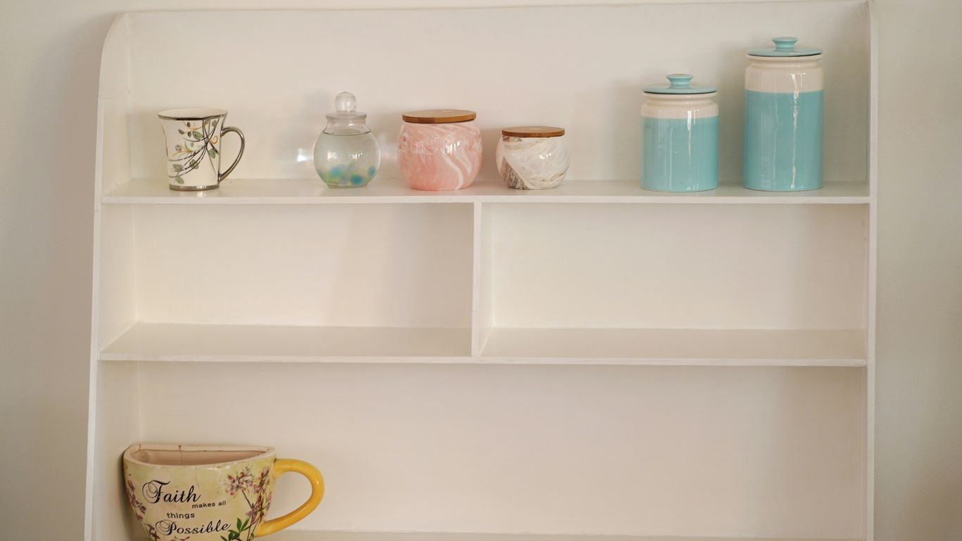 a shelf with a cup and mugs on it