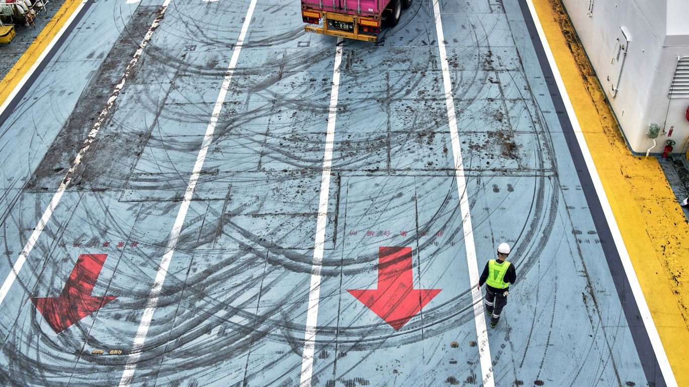 A man walking across a parking lot next to a truck