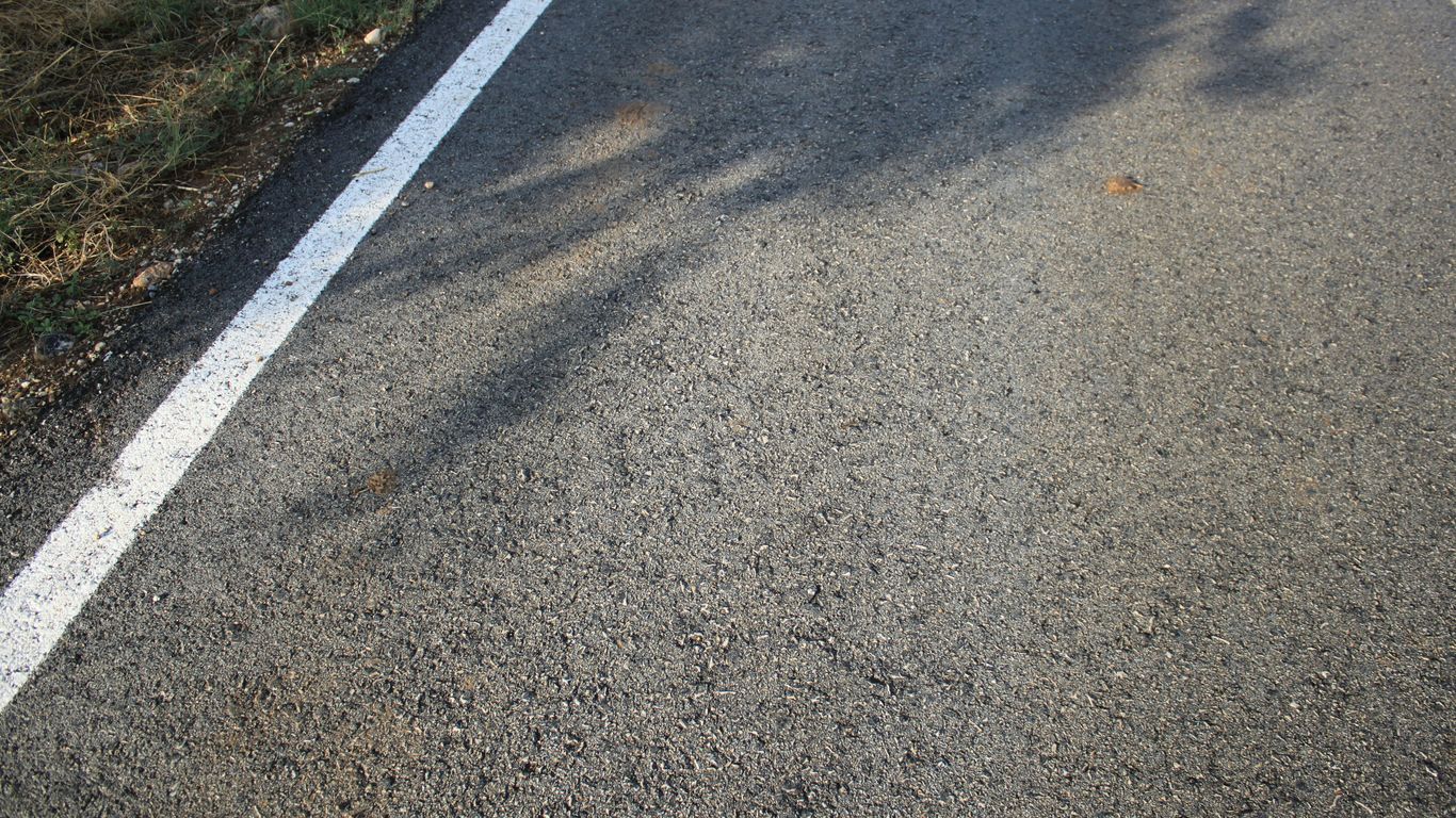 Asphalt road with a white line and shadows