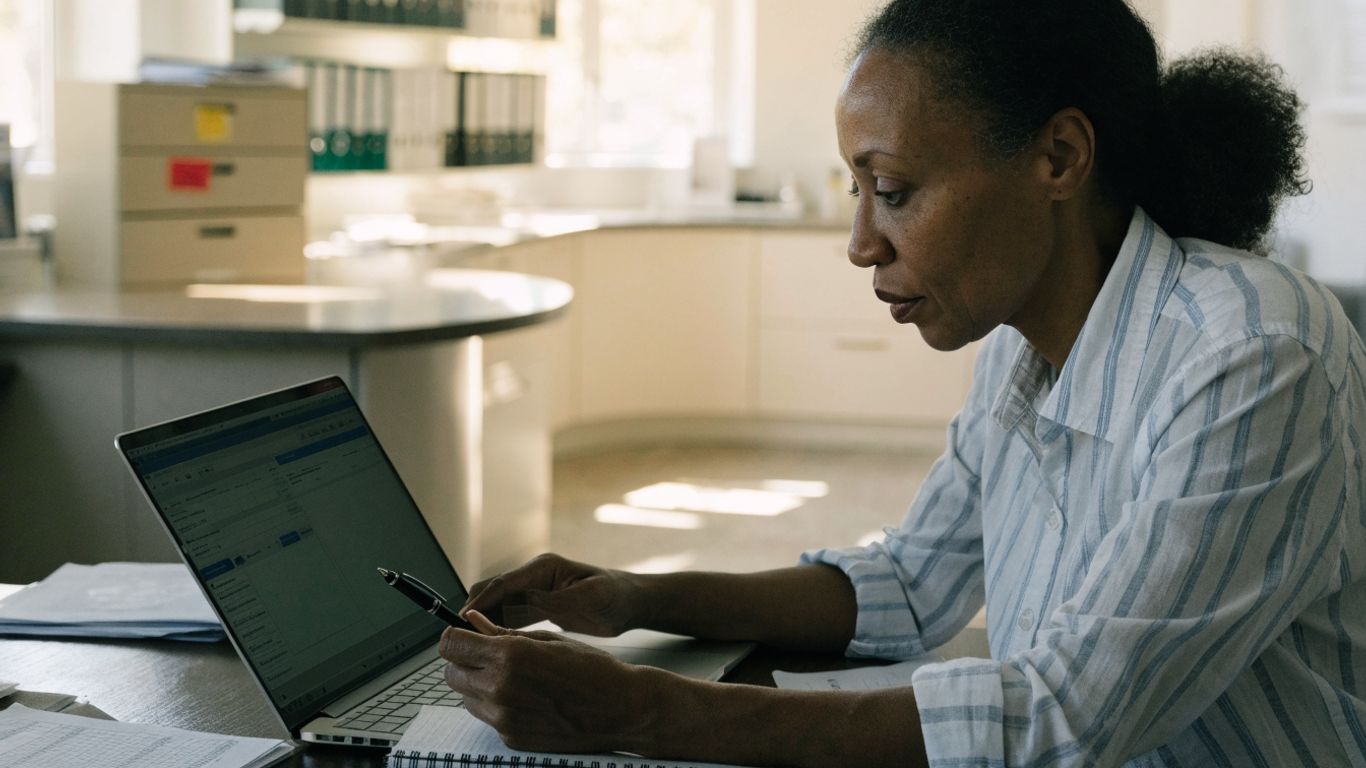 Practice manager comparing software options at a desk