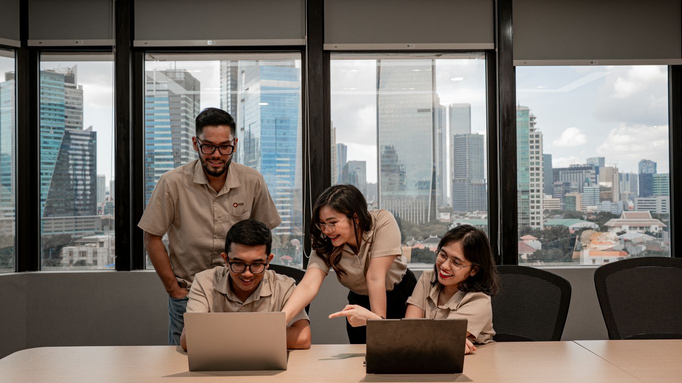 Team collaborating on laptops in modern office