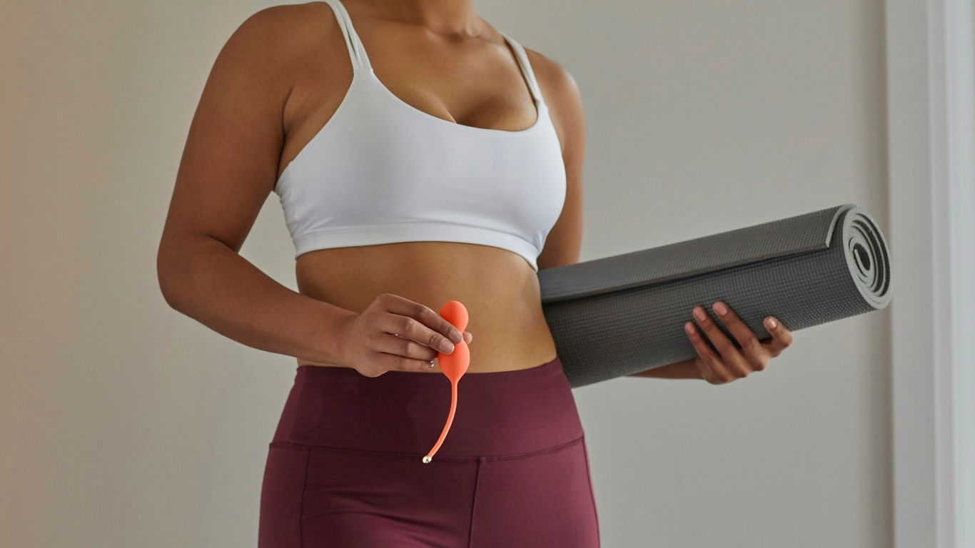 A person holding a yoga strap during a seated exercise.