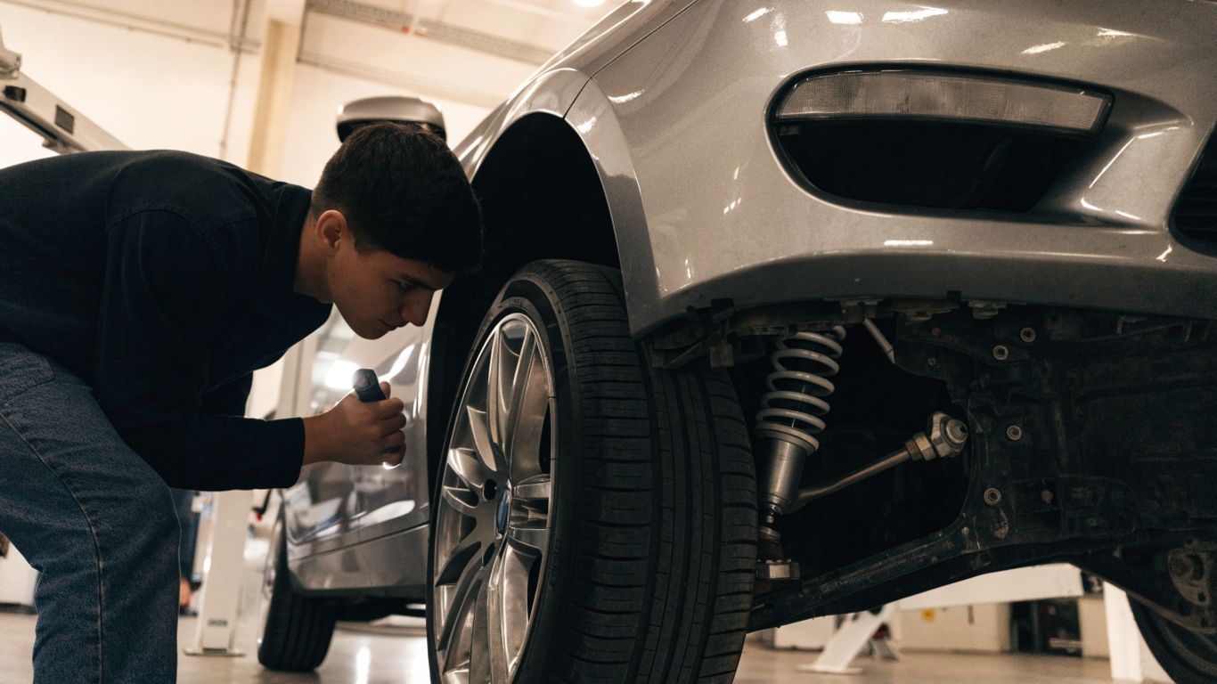 Mechanic inspecting a BMW suspension assembly