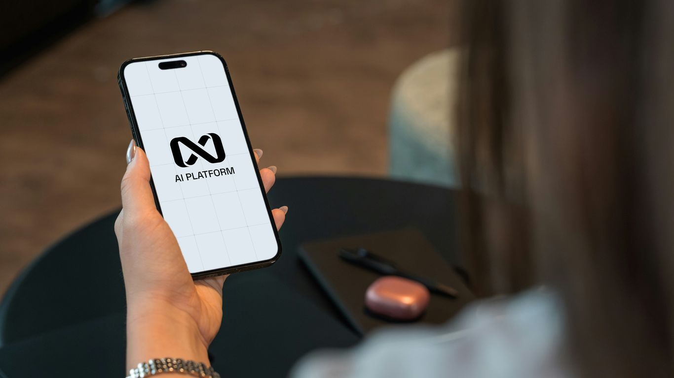 Person holding a smartphone with a logo on screen.