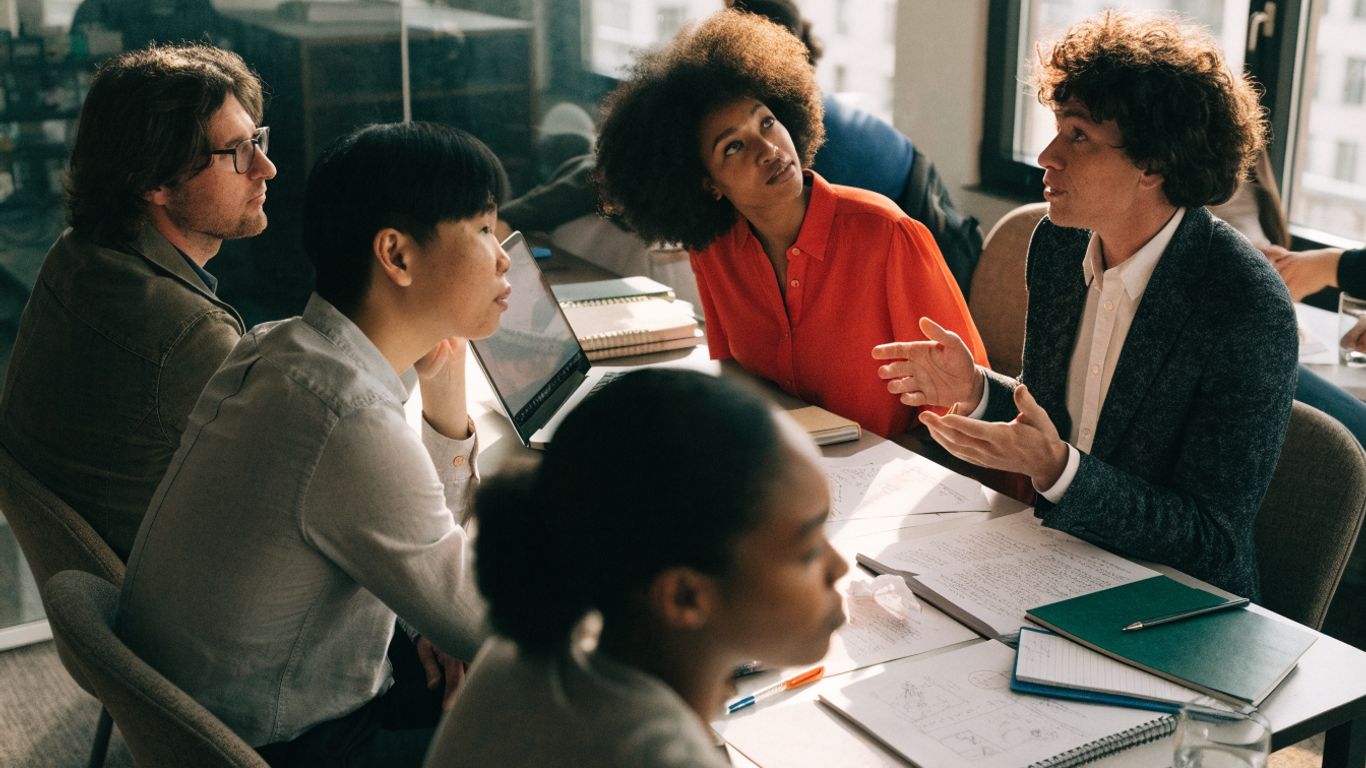 Colleagues discussing a project around a table